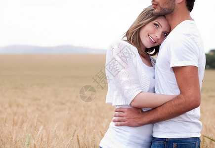 男人和女在草丛中拥抱着图片