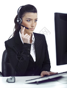 忙碌的女人认真听到顾客用耳机说话而不是白背景图片