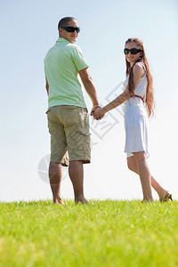 快乐的年轻夫妇在公园散步图片