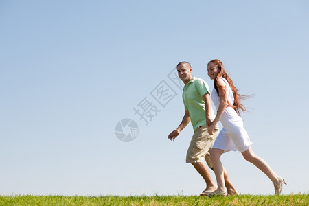 在公园中牵手奔跑的夫妇图片