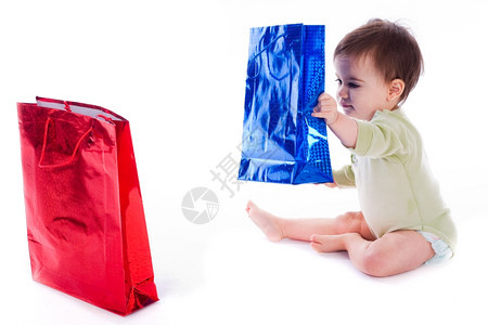婴儿抱着购物袋在孤立的white背景图片