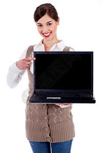 妇女手持笔记本电脑并以孤立的背景指着笔记本电脑的肖像图片