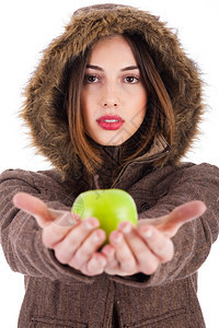美丽的年轻淑女身着绿苹果穿皮大衣头盖在白色背景上图片