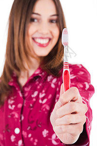 年轻女用白色背景展示牙刷图片