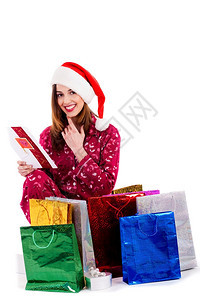 年轻女士阅读圣诞节卡周围都是礼物袋图片
