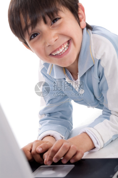 带着笔记本电脑在白色背景上微笑的可爱caucasian男孩的肖像图片