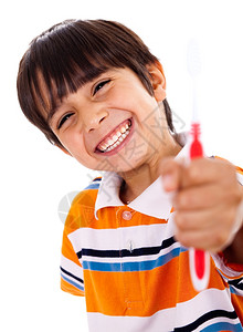 快乐的小男孩展示牙刷在无声背景上图片