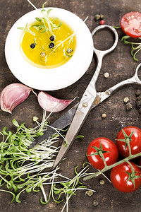 旧厨房桌上的芽大蒜番茄橄榄油和剪刀图片