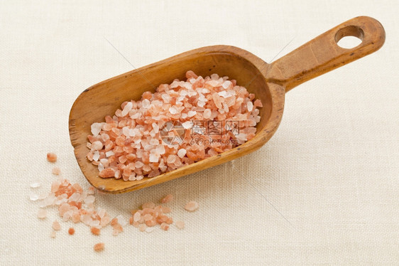 铁制木勺上粉红和橙色喜马拉雅盐的粗晶体图片