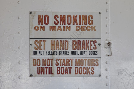 在旧金山海洋历史公园的Eureka旧轮渡船Eureka的白墙上签禁烟和指示图片