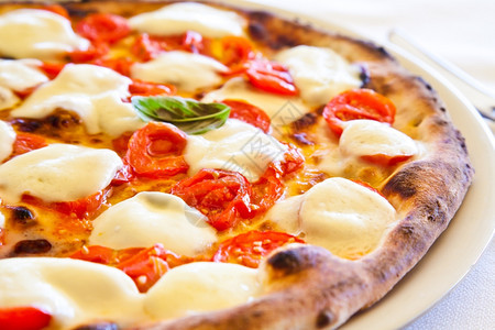 这是一个真正的意大利比萨饼传统的玛格丽塔披在意大利那不勒斯湾的卡普里和柯克餐馆服务图片