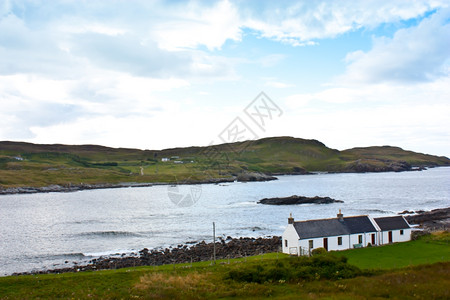 湖前有苏格兰传统房子的全景图片