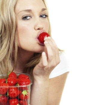 吃新鲜草莓的年轻美女图片