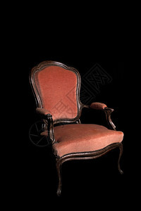 黑色背景的古董红臂椅图片