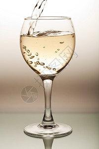 白葡萄酒倒入玻璃杯中图片