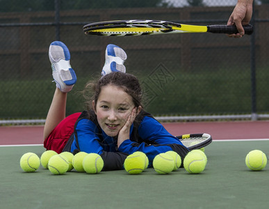 和教练一起在户外网球场玩得开心的年轻女孩图片