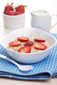蓝色碗里富含维生素的草莓燕麦粥背景图片