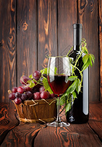 红葡萄酒木背景的红酒杯图片