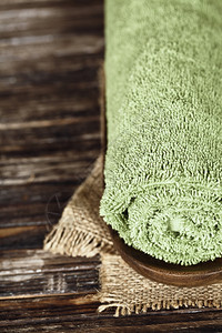 木质表面的绿毛巾图片