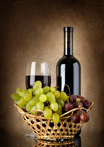 红酒和葡萄瓶装在背景画布上图片