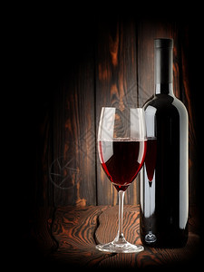 红葡萄酒木背景的红酒杯图片