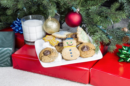 白盘上自制饼干加牛奶杯作为圣诞礼物送给老人图片