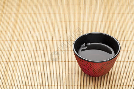竹子垫上日本茶杯传统铸铁的红荷布奈尔设计里面有黑炼油图片