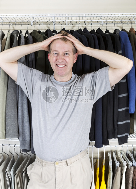 穿衣柜的成年白人男子垂直肖像在拉头发时对部背后的双手感到沮丧图片