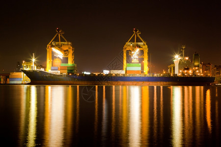 夜间在曼谷造船站码头卸载和装货物的工业船舶具有作起重桥的机用于物流进口背景图片