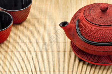 竹垫上日本的Tantsubin和茶杯图片