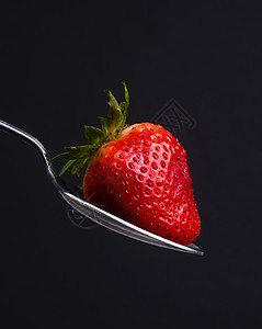 银勺苏灭水Utensil持有新鲜生食品红草莓糖片图片