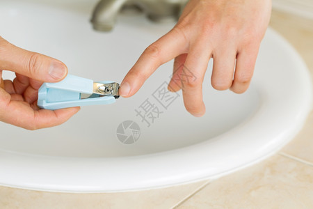女手在浴室用水槽和背底反顶洗手间剪指甲的横向照片背景图片