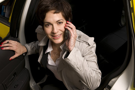 女旅客坐在计程车上打电话图片
