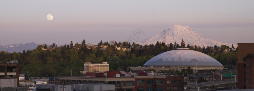 满月出现在MtRainier山和Tacoma穹顶附近的地平线上图片