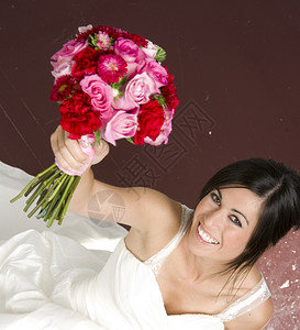 Bouquet提高快乐新娘穿着白色结婚礼服Gowd图片