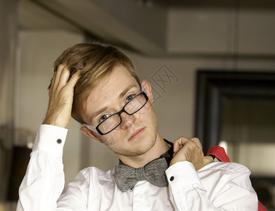 穿白衬衫戴眼镜的年轻英俊时装男模特身着白衬衫内衣领带图片