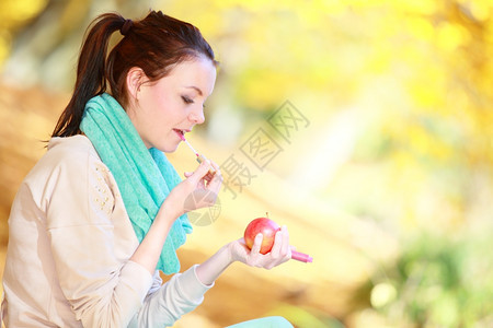 秋叶生活方式概念和谐自由在秋天公园用红苹果口苹果来放松的偶然年轻女孩金色的叶子背景图片