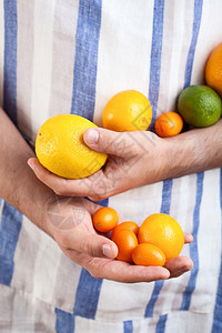 手握柑橘水果的人图片