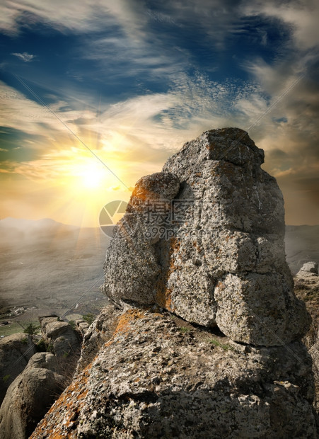 日落时山上岩石的风景图片
