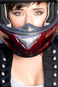 近距离的红色满脸的女孩头盔在摩托车上图片