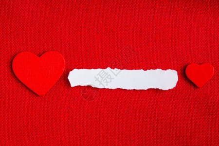 一张白纸的小块空复制间和爱的心符号在红色织物纺材料背景上情人节图片