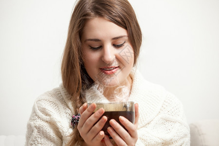 褐色女人的肖像看着蒸发的茶杯图片