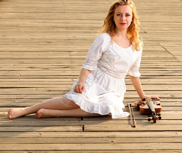 金发女孩音乐情人和小提琴在码头喜欢音乐概念图片