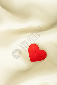 情人节39白天或婚礼红木装饰心脏在抽象的白色背景上奢华的丝绸或带复制空间的刺青织物上图片