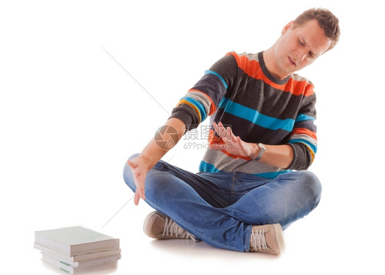 穷疲累的大学生在白种背景孤立的考试中学习书籍堆积如山图片