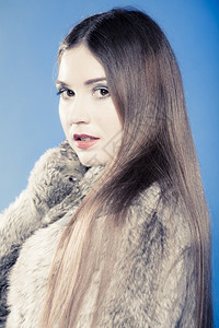 穿着蓝色毛衣的年轻女人工作室拍的冬季时装图片