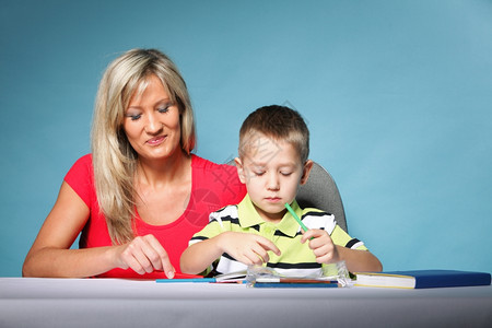 母亲帮助儿子做家庭作业图片