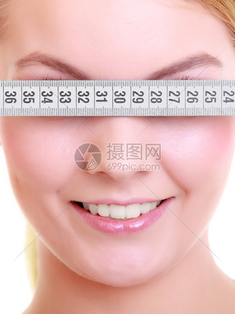 健美的女运动子用白色隔离的测量胶带遮住她的眼睛图片