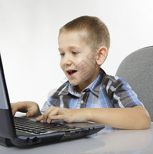 电脑情绪的儿童男孩笔记本电脑玩白种背景孤立的游戏图片