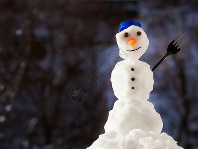 圣诞小雪人快乐蓝螺帽顶端是子和叉冬季节特别模糊的背景图片